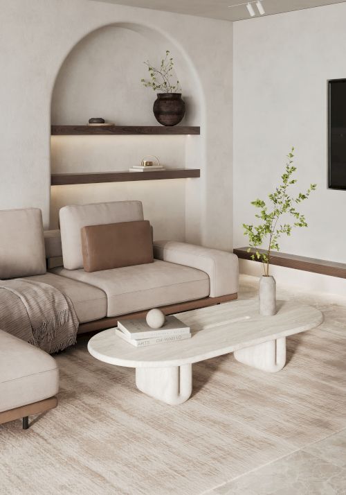 A modern living room with a beige sectional sofa, an oval coffee table, shelves with decor items, and a potted plant in the corner, all on a light rug.